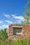 Desolate brick house ruins in the meadow on sunny day