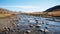 Desolate Landscapes: A River Flowing Through A Field Of Large Rocks