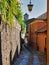 Desolate street with via and stone walls on the San GIulio Island in Lake Orta Italy with the belfry of San Giulio Basilica in the