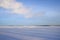 The desolate winter landscape of snow and shadows to the foreground