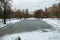 Desolated pensive frozen pond in city park.