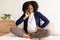 Despaired curly pregnant millennial black woman in domestic clothes with big belly calls by phone