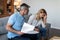 Despaired sad mature caucasian couple work with documents, pay bills, taxes have stress in living room