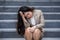 Desperate Asian American businesswoman crying alone sitting on street staircase suffering stress and depression crisis being