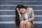 Desperate Asian Chinese businesswoman crying alone sitting on street staircase suffering stress and depression crisis being victim