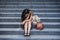 Desperate Asian Korean business woman crying alone sitting on street staircase suffering stress and depression crisis being victim