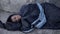 Desperate black man lying street covered with sleeping bag, poverty hopelessness