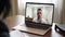 Desperate Caucasian young man holding hands together as praying talking to unrecognizable psychologist in video chat