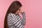 Desperate emotions, depression, Side view of unhappy sad woman in striped sweatshirt standing with bowed head