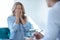 Desperate female patient covering her face, consulting with female doctor