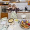 Desperate housewife with hands in the hair for mess in kitchen she will have to fix