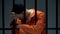 Desperate imprisoned male leaning on bars, feeling depressed, psychological help