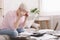 Desperate senior woman counting her tiny budget at home