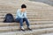 Desperate student sitting on stairs outdoors