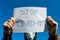 Desperate teenage boy wearing surgical mask holding a message in isolation during the new Coronavirus