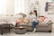 Desperate woman sitting on sofa in messy room