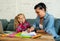 Desperate woman trying to help her daughter studying and doing homework while the girl is complaining bored of studying in