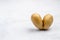 Despicable potatoes in the shape of a heart on a gray background, copy space place