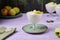 Dessert, airy apple mousse garnished with almond and apple slices, in a transparent bowl on a purple wooden background. Desserts