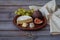 Dessert appetizers to wine - figs, brie cheese, red grapes served on a ceramic plate, next to a linen napkin