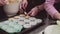 Dessert baker hand puts dough in muffins parchment paper cups on baking tray