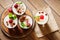 Dessert with berries, jelly, cream, nuts and mint leaf on a cutting wooden board