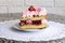 Dessert biscuit cake with strawberry jam, whipped cream and fresh strawberries on a white napkin