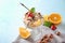 Dessert bowl with tasty oatmeal, fruits and nuts on color background