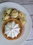 Dessert Cake with white cream in a basket of dough Blooming yellow roses Saucer on a wooden table Close-up