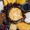 Dessert cheese plate with Castagnino Italian Goat Robiola soft cheese in Chestnut Leaves served with jams and grapes