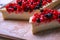 Dessert cheesecake with redberries and blueberries on wooden board and sugar powder. Close up top view