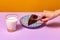 Dessert. Food pop art photography. Plate with cake on lilac color tablecloth over orange background. Vintage, retro