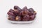 Dessert Medjoul jumbo dates in a transparent bowl isolated on the white background.