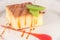 Dessert of mellow cheese cake with caramel and two slices of kiwi.