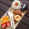 Dessert platter on wooden board with brownies, tart, fruit, bran