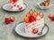 Dessert, sliced sponge cake with custard, fresh strawberries and whipped cream on a gray concrete background. Swedish cuisine