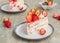 Dessert, sliced sponge cake with custard, fresh strawberries and whipped cream on a gray concrete background. Swedish cuisine