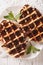 Dessert waffles with chocolate topping on a plate close-up. vert