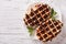 Dessert waffles with chocolate topping on a plate. Horizontal to