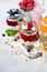 desserts with muesli, berries and fruit in jars, vertical
