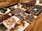 Desserts for Sale in Display with Donuts, Buns, Brownies, Cakes on Wooden Surface at Cafe Shop Showcase