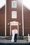 Destination Iceland wedding. Wedding couple in front of a black church. The groom hugs the bride.