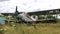 Destroyed and abandoned plane standing in thick grass of overgrown field