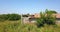 Destroyed barn with large hole in roof near fresh corn field