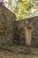 Destroyed column and walls of an ancient fort overgrown with banyan trees in the green jungle