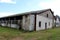 Destroyed dilapidated long hangar buildings with broken windows and cracked walls at abandoned military complex