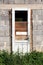 Destroyed dilapidated white wooden doors with cracked paint and boards without glass mounted on brick wall of abandoned house