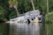 Destroyed Flat bottom barge style boat rests on its side, damaged by hurricane