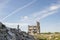 Destroyed large building with a blockage of concrete debris in the foreground. Background