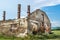 Destroyed old brick house without roof and with chimneys, broken windows, window frames, door and bricks